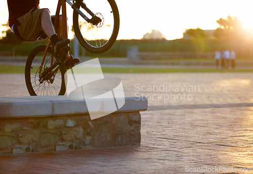 Image of Closeup, bike and man outdoor, trick and sun flare with training, fun and wellness. Male person, cyclist or biker outside, free style and extreme sports with freedom, professional cycling and parkour