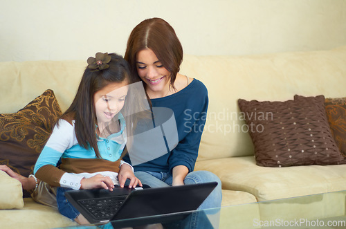 Image of Love, laptop and mother with her kid on a sofa browsing on social media while bonding together. Happy, smile and young mom on the internet with her girl child on computer in living room at their home