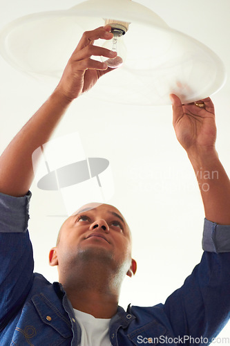 Image of Light fixing, electrician and man working on a home improvement job for contractor project. Building maintenance, professional service and builder doing electrical work for lightbulb fix in house