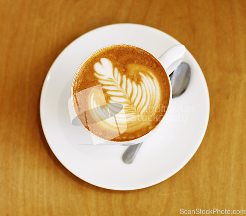 Image of Latte art, coffee and top view of drink on table in cafe, closeup of hot beverage and artistic design with milk foam. Cappuccino, espresso and creative pattern on caffeine liquid brew in a cup