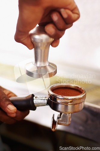 Image of Coffee, ground and barista hands press espresso with tamper, portafilter and fresh caffeine at cafe, hotel or restaurant. Brewing, beverage or cappuccino machine equipment for professional drink