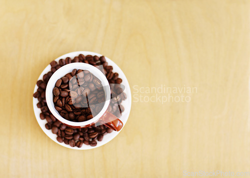 Image of Coffee beans, roasted and cup for cafe industry with quality product and space for marketing or advertising. Above wooden table mockup background with grain as drink, espresso or caffeine ingredient