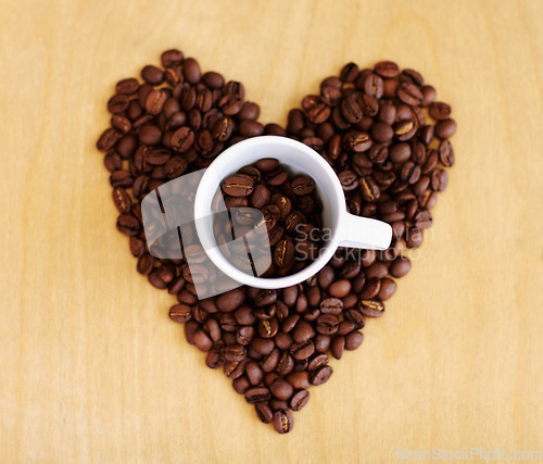 Image of Heart, roasted coffee beans and cafe industry with love icon or emoji for marketing and advertising. Above wooden table or background with grain shape as drink, espresso or caffeine ingredient