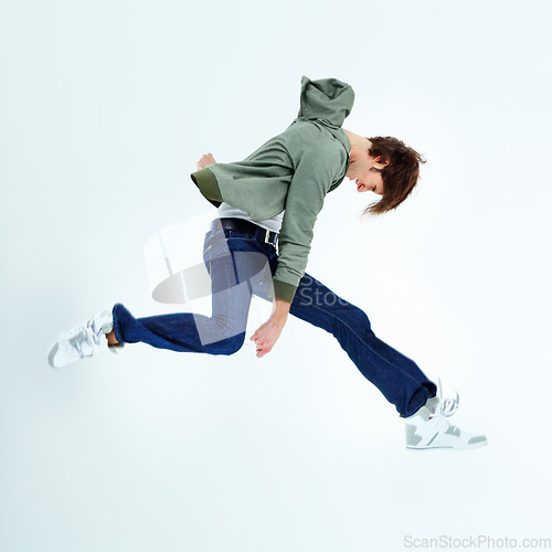 Image of Young man, leaping and fashion jumping in style, excitement or hip against a studio background. Happy male model in air jump with stylish casual clothing, jacket and jeans isolated on mockup