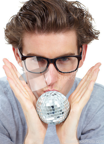 Image of Disco ball, kiss and portrait of a man with celebration, party and clubbing decoration in a studio. Isolated, white background and young male person with model face kissing a small partying deco