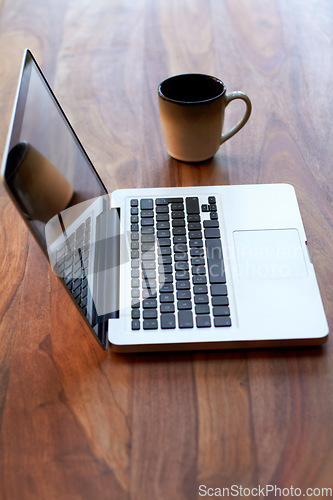 Image of Remote work with a coffee and laptop on a desk for blogging or social media browsing at a modern restaurant. Computer, freelance and research with wireless technology on a wooden surface from above