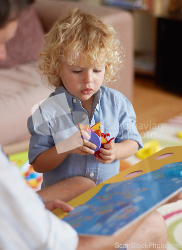 Image of Father with boy kid, reading book for education and development, spending quality time together at home. Family, teaching and learning with man and child bonding, picture story with toys for growth