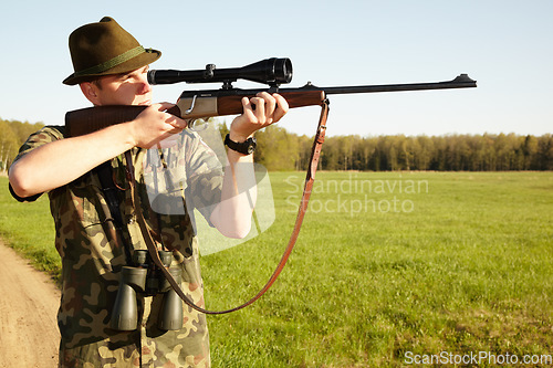 Image of Hunter, gun and man in nature on a Africa safari for animal shooting with a weapon on vacation. Hunting sport, male person and target hunt practise of a traveler in camouflage looking at a scope