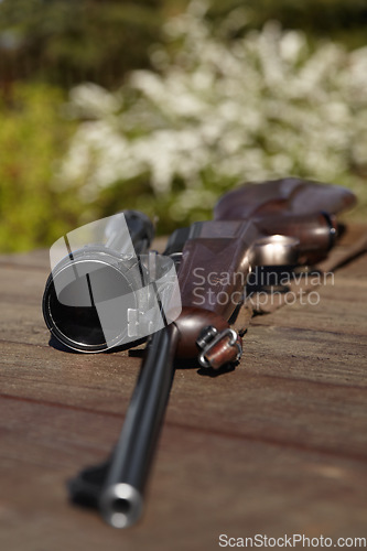 Image of Hunting, rifle and weapon with a gun on a table outdoor in nature on a game reserve or blurred background. Sports, scope and sniper with hunter or military equipment on a wooden surface outside