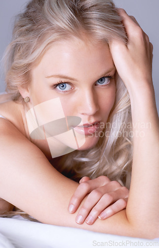 Image of Beauty, closeup and portrait of woman on bed for sensual, makeup and attractive. Relax, cosmetics and glamour with face of female model in studio for desire, sensuality and elegant style