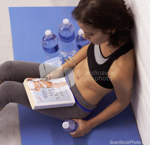 Image of Top view, diet and woman with a book, water and fitness for wellness, training and weight loss. Female person, human or model with liquid, reading or workout goal with a healthy lifestyle and fatigue