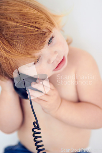 Image of Phone call, playing and cute young kid at home with ginger hair and youth. Conversation, telephone and learning child with communication and listening in a house with confidence and childhood