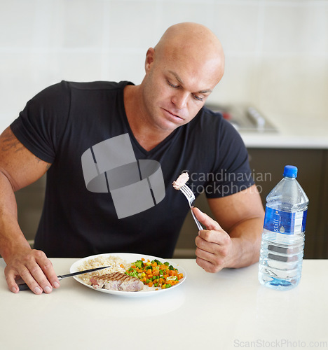 Image of Bodybuilder man, food and eating in home with meal, water and healthy protein for wellness, diet or hungry. Guy, body builder and steak for dining, nutrition or health at dinner for lifestyle