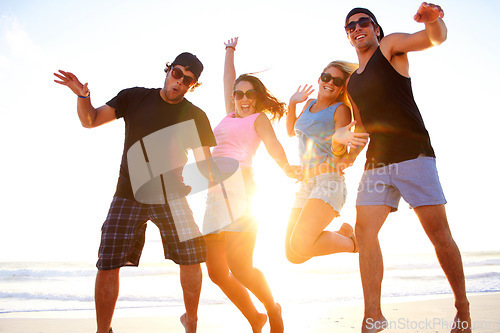 Image of Friends, jump and beach portrait in sunset with freedom, youth and happiness on vacation together. Excited men, women and smile outdoor by ocean, sunshine and waves in summer, holiday and happy group