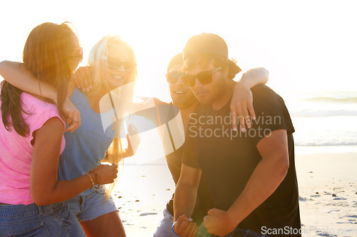 Image of Group, friends and talking on beach at sunset with freedom, youth and funny on vacation together. Excited men, women and comic joke by ocean, sunshine and hug on summer holiday with happy laughing