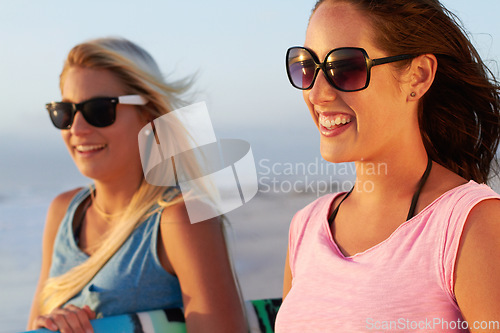Image of Summer, beach and woman friends surfing outdoor in nature together while on tropical holiday or vacation. Smile, sunglasses and a happy young female surfer with her friend on the coast to surf