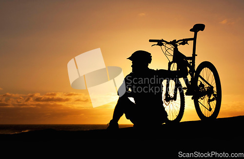 Image of Sunset, silhouette and bike with man at beach for relax, fitness and vacation trip. Travel, cycling and sky mockup with male cyclist and bicycle on coastline for training, peace and sports hobby