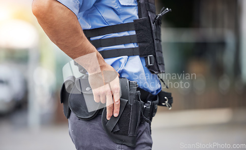 Image of Gun, uniform and police in the city for crime, security and outdoor justice in the street. Law, safety and a closeup of a man with a weapon in town for legal services, criminal or protection