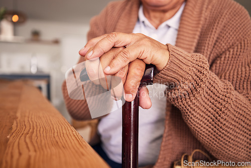 Image of Closeup, hands and cane of person with disability, arthritis and aid of osteoporosis, parkinson or stroke. Retirement, senior patient and holding walking stick of support, help or healthcare mobility