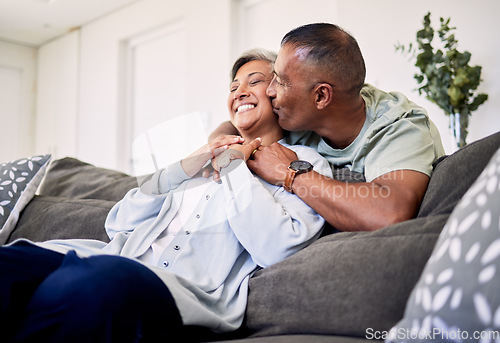 Image of Hug, surprise kiss and happy elderly couple bonding, relax and spending time together, smile and enjoy home retirement. Living room, love or senior man, old woman or sweet people with marriage care