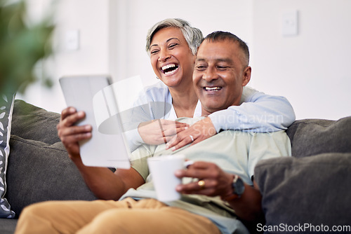 Image of Home, tablet or senior couple laughing, happy and reading funny email, news article joke or social media meme. Website comic, comedy blog or elderly man, old woman or people smile on living room sofa