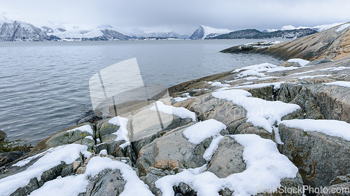 Image of Snow-covered coastline with mountains on the horizon