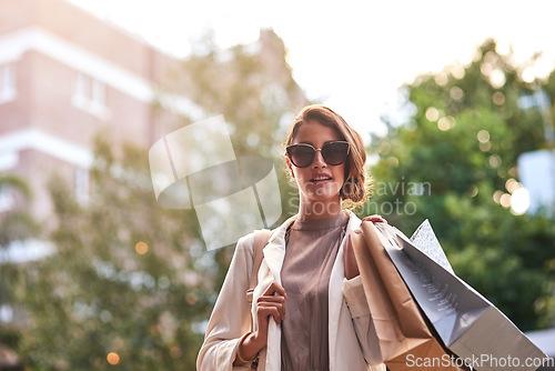 Image of Portrait, shopping bags or rich woman in city or urban street for boutique retail sale or clothes in sunglasses. Smile, client or fashionable girl customer on city road walking with luxury products