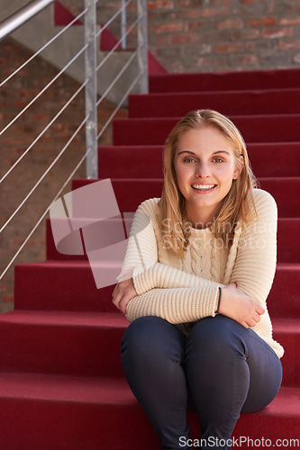 Image of Campus life. Portrait of a university student sitting on a staircase at campus.