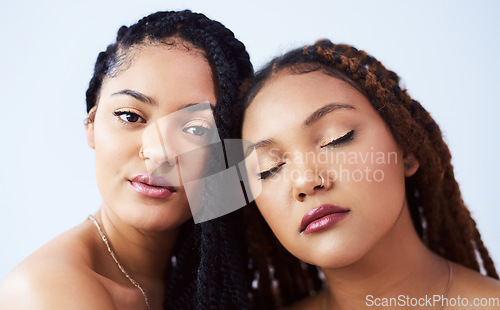 Image of Beautifully brown and glowing. Studio shot of two beautiful young women posing against a grey background.