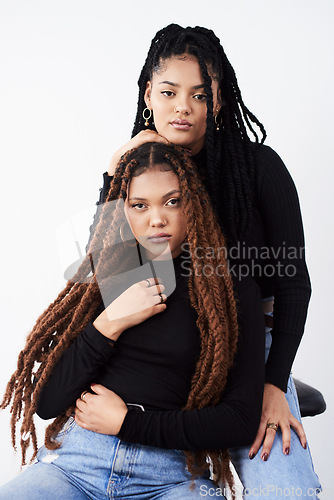 Image of Long natural hair is what they love. Studio shot of two beautiful young women posing against a grey background.