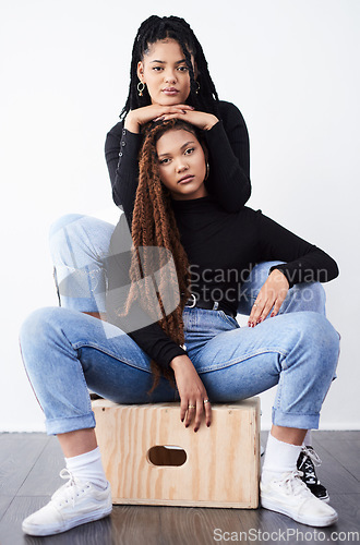 Image of They love being fashionable together. Studio shot of two beautiful young women posing against a grey background.