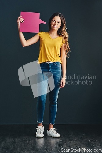 Image of Speak up when it will help others. Studio shot of a beautiful young woman holding a speech bubble.