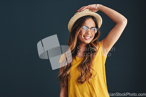 Image of Im ready for hats and sunny days. Studio shot of an attractive young woman against a dark background.