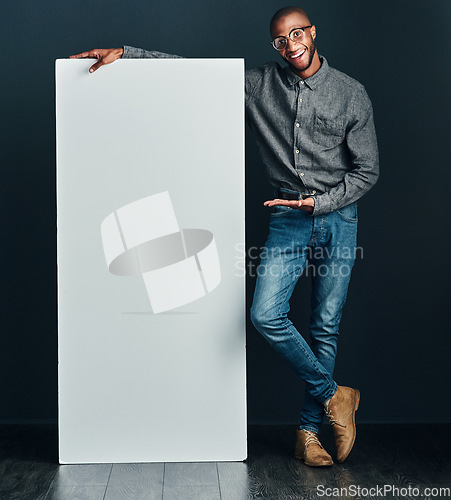 Image of Are you interested. Shot of a handsome young man standing next to a blank placard.