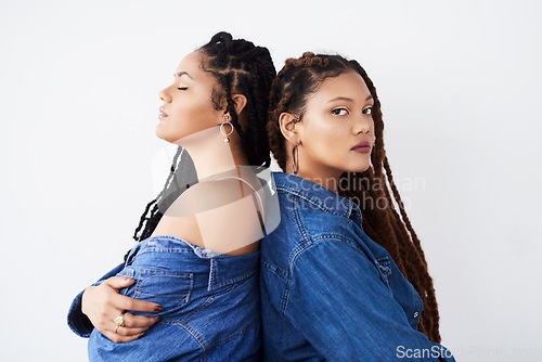 Image of They love to match their catching style. Studio shot of two beautiful young women posing against a grey background.