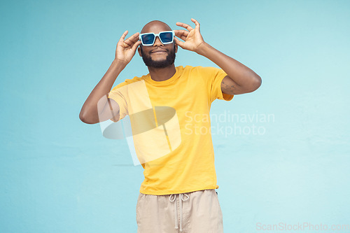 Image of Sunglasses, black man and fashion on a blue background with cool and trendy style with mock up space. Young model person with eyewear in studio for advertising designer brand, logo or color in hands