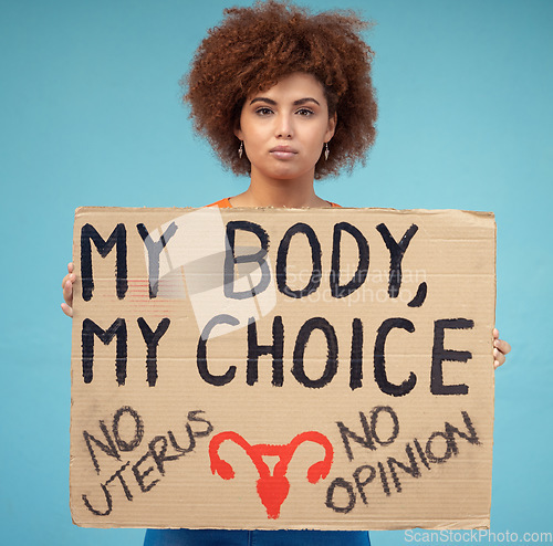 Image of Black woman, portrait and poster to protest abortion, body choice and freedom of human rights in studio. Feminist, rally and sign for safe decision, equality and support of justice on blue background