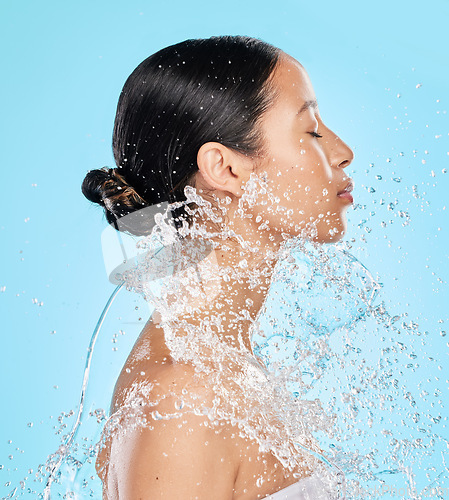Image of Beauty, water and face of woman on blue background for wellness, healthy skin and cleaning in studio. Skincare, shower and female person profile with splash for facial grooming, washing and body care