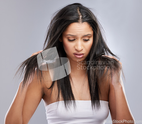 Image of Hair, damage and face of woman with worry for split ends, haircare crisis and weak strand in studio. Beauty, hairdresser and upset female person with frizz, loss and dry problem on gray background