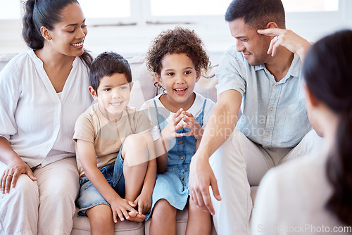 Image of Parents, kids and counselling with psychology, smile and together on sofa, support and discussion. Young family, children and happy on couch with psychologist, listening and talking for mental health