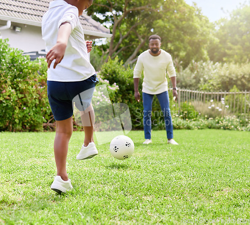 Image of His coordination gets better with practice. Shot of a little boy kicking a soccer ball to his father while playing together outdoors.