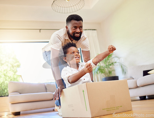 Image of Father, son and playing at home with pretend car in a box on moving day in new property. Black family, house and real estate move of a dad and child together with play driving and fun in living room