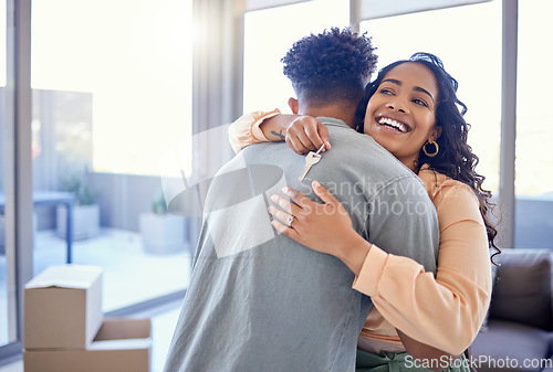 Image of Happy couple, hug and real estate with key for new home, moving in or mortgage loan together indoors. Woman hugging man with smile in happiness, property or investment with keys to apartment building