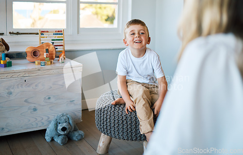 Image of Therapist, psychology and boy on a chair, talking and child development with a smile, foster home and adoption. Male kid, young person or counsellor in an office, speaking and consultation for growth