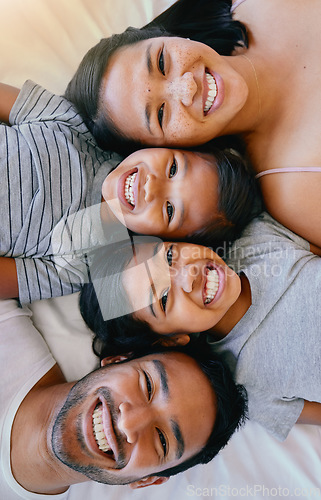 Image of Portrait, smile and above asian family in bed, relax and having fun while bonding in their home. Top view, love and face of children with parents in bedroom, happy and resting together on the weekend