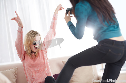 Image of Crazy women friends with a photography camera in happiness together and being silly in a home living room. Fun, people and photographer take pictures of a happy female person celebrating