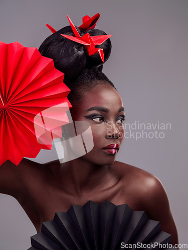 Image of Beauty, makeup and origami with black woman in studio for creative, art and culture. Traditional, cosmetics and paper design with female model and fans on grey background for oriental, retro or color