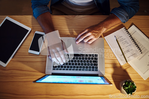 Image of The tools of greatness. Shot of an unrecognised businessman working late at night on his computer in a modern office.