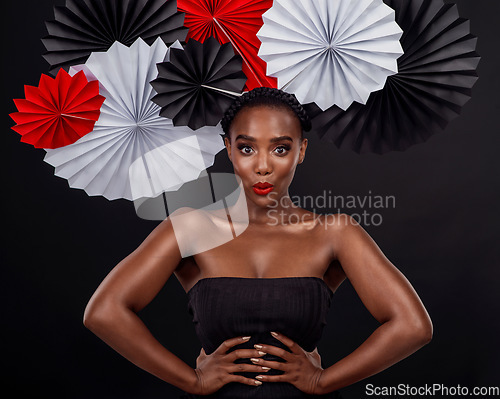 Image of Face, beauty and black woman with origami fans in studio isolated on a dark background. Portrait, makeup cosmetics and skincare of female model with traditional Japanese paper hat for fashion art.