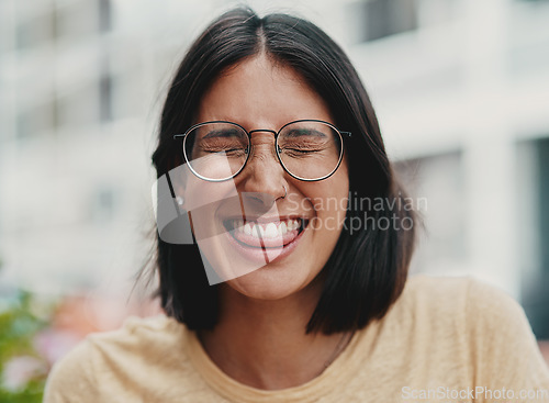 Image of A little bit of fun never hurt anyone. Cropped shot of an attractive young businesswoman sitting alone outside and feeling playful while making a face.